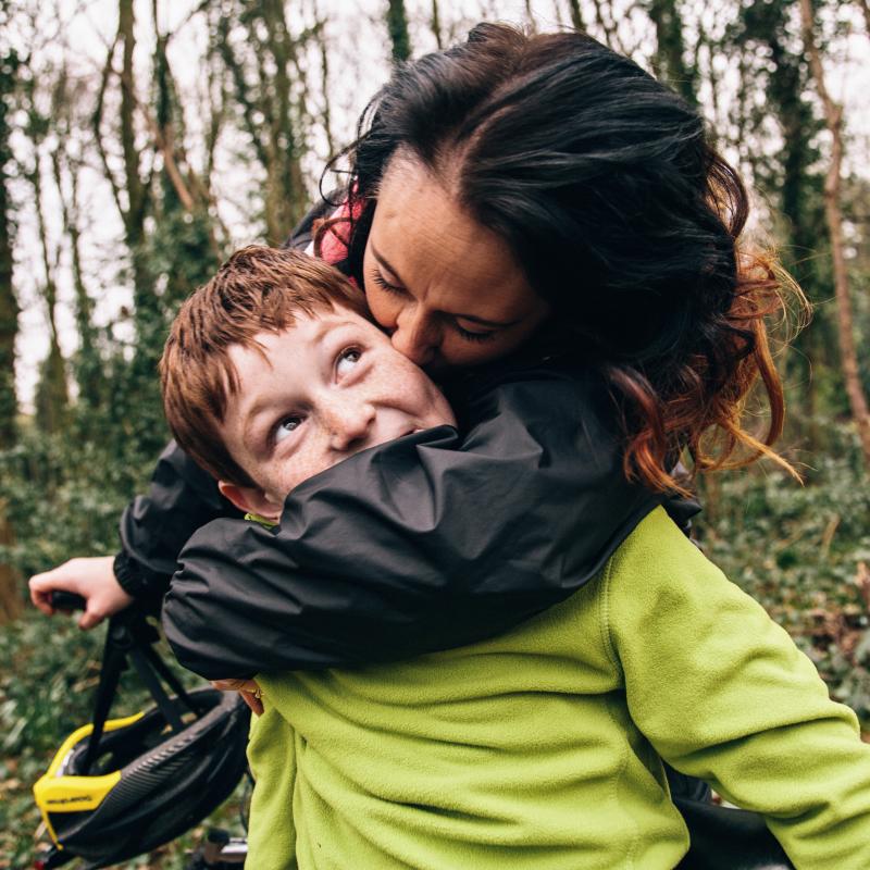 Mamá besando a su hijo durante un paseo en bicicleta.